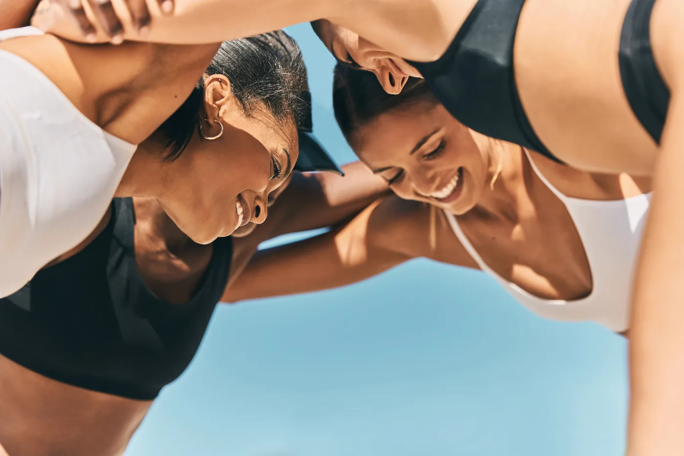 Two Moai members laughing together in a huddle after a workout